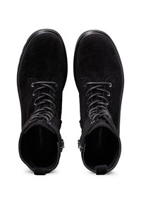 Botines de ante negros hasta el tobillo con puntera redonda, cierre de cordones en la parte delantera, superficie texturizada y ojales en tono plateado. Cuenta con una cremallera lateral y un interior con marca.