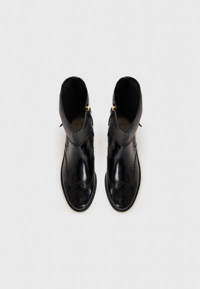 Black leather ankle boots with smooth finish, decorative perforated pattern, scalloped edge, and side zippers for easy wear.
