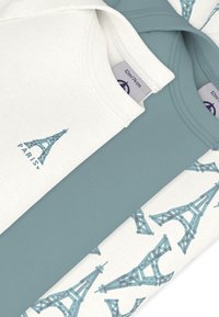 Σετ τριών t-shirts: ένα εκρού με γραφικό Πύργου του Άιφελ, ένα μπλε και ένα εκρού με επαναλαμβανόμενο μοτίβο Πύργου του Άιφελ. Απαλό βαμβακερό ύφασμα.