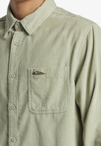 Groene corduroy overhemd met een button-down kraag, een voorke pocket en een subtiele streeptextuur. Inclusief een klein geborduurd logo op de pocket.