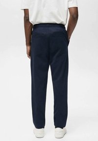 Marineblå sweatpants med en afslappet pasform, elastisk talje og to baglommer. Fremstillet af blødt stof med en glat tekstur.