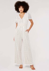 White lace jumpsuit with short ruffled sleeves, V-neck design, wide-leg silhouette, vertical patterns, and side pockets.