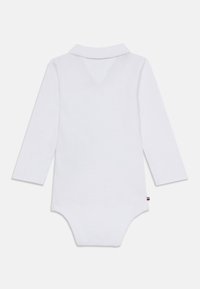 Fehér, hosszú ujjú body, gallérral, sima textúrával és kis márkajelzéssel az alján. Egyszerű dizájn, minta nélkül.