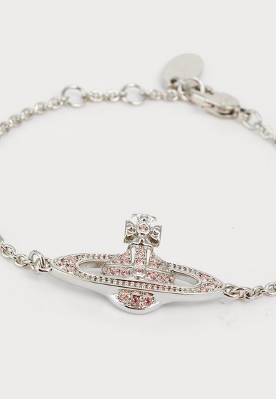 Silver bracelet with a central oval design, featuring pink gemstones and a cross accent. Linked chain with a lobster clasp closure.