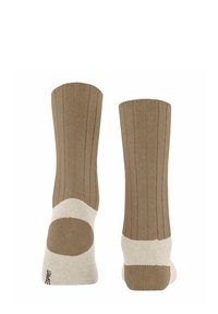 Braune gerippte Socken mit einem cremefarbenen Fuß- und Knöchelband, aus einem weichen Material gefertigt. Hervorgehoben durch ein markenlogo an der Unterseite.
