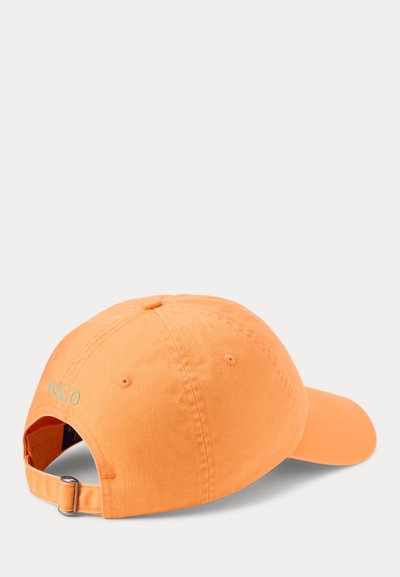 Oranža kokvilnas cepure ar izliekto mali, regulējams aizmugurējais siksniņš un "POLO" izšūts gaiši zaļā krāsā aizmugurē. Gluda tekstūra.
