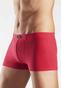 Rote Baumwoll-Boxershorts mit körperbetontem Design, featuring einer glatten Textur und einem kontrastierenden Logopatch am Bund.