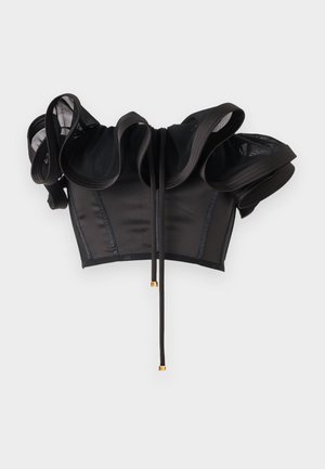 Čierny odhalený crop top s volánkovými sieťovanými rukávmi a prednými viazačkami so zlatými kovovými koncovkami, zobrazený na jednoduchom svetlom pozadí.