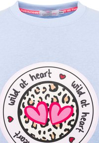 Jasnoniebieska bluza z okrągłym białym wzorem na środku w leopardzie plamki, różowymi sercami i czarnym napisem "dziki w sercu".