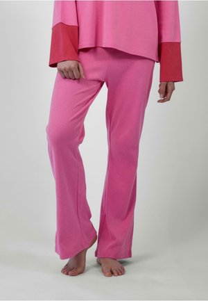 Pantalons de lounge en coton rose avec une légère évasement au bas. Texture lisse, taille élastique et coupe décontractée. Pas de motifs ou d'accents visibles.