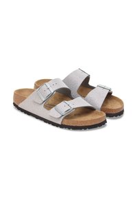 Zilveren glinsterende slide sandalen met twee verstelbare banden, metalen gespen, kurken voetbed en een getextureerde rubberen zool.