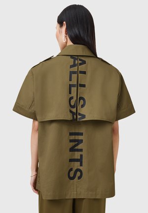 Camisa de manga corta color caqui con un gran gráfico negro de "ALLSAINTS" en la parte posterior, con un corte relajado y una textura de tela suave.