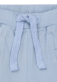 Lichtblauwe jogger tailleband met een geribbelde textuur, voorzien van een geweven trekkoord en verstevigde stiksels aan de zijkanten voor extra duurzaamheid.