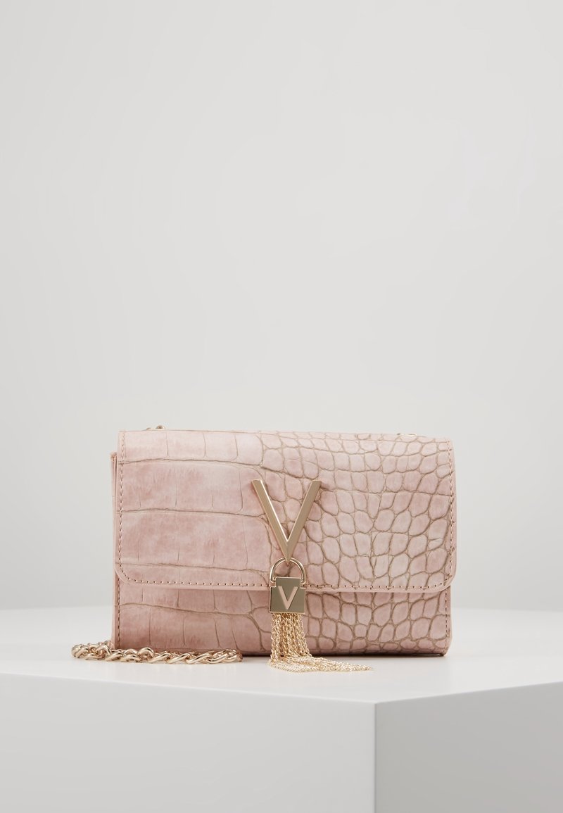 Sac à main en cuir synthétique rose avec texture crocodile, accessoires dorés, bandoulière en chaîne et accent décoratif en forme de V avec des franges.