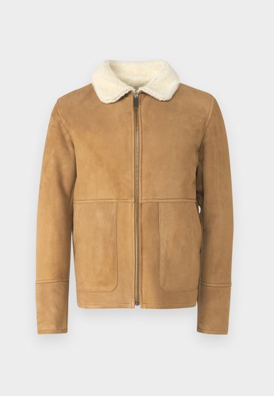 Tan suedjakke med faux shearling krave, lynlås foran og to frontlommer. Glat tekstur, skræddersyet pasform, minimale syninger.