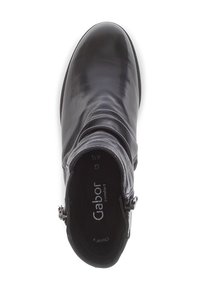 Botín de cuero negro que presenta un diseño fruncido, cremallera lateral y punta redonda. El interior incluye una plantilla acolchada con el logo de la marca.