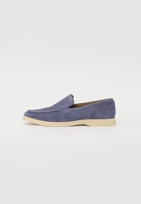 Kék velúr lofer cipők, lekerekített orral, minimális varrással és bézs gumi talppal. Könnyen felvehető slip-on kialakítással rendelkezik.