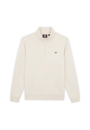 Jasno beżowy polarowy pulower z ćwierć zamkiem błyskawicznym i małym logo na klatce piersiowej. Posiada długie rękawy i miękką, gładką fakturę.