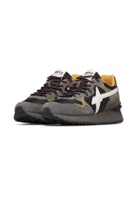 Ett par grå och svarta sneakers med vinröda snören, vit stjärnlogotyp och gul innersula, visade från framsidan på vit bakgrund.