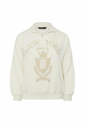 Sudadera de color crema con cuello con cremallera, que presenta un gran diseño gráfico y emblema en color beige claro que dice "NUEVA YORK" en la parte delantera.