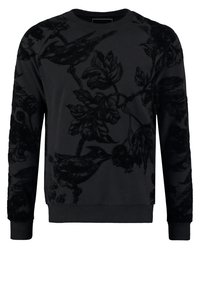 Svart sweatshirt med en texturerad blommig och fågelmönster, rundad hals och ribbade ärmar. Designen kompletterar den enfärgade bakgrunden.