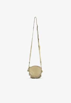 Ronde beige leren crossbodytas met verstelbare band en kleine decoratieve metalen bedels langs de onderrand.