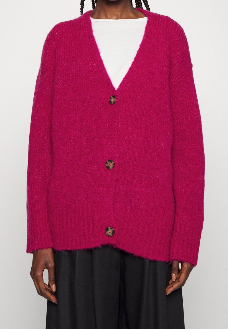 Fuchsie pletený cardigan s volným střihem, výstřihem do V a pěti knoflíky. Má žebrované manžety a lem, vyrobený z texturované příze.