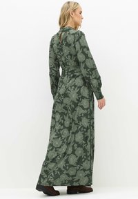 Groene bloemen maxi-jurk met lange mouwen, een getailleerde taille en knoopsluiting aan de achterkant. Beschikt over een gladde textuur en een vloeiende uitstraling.