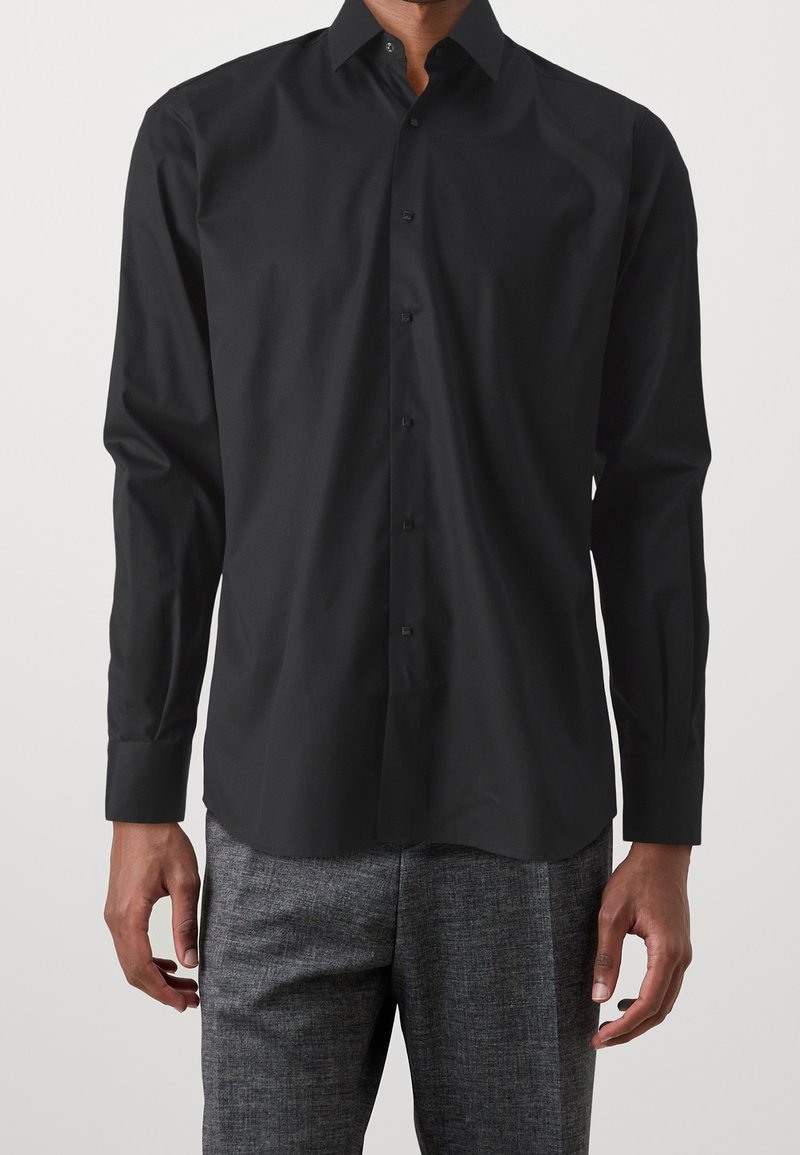 Zwarte lange mouwen knop-up shirt met een klassieke kraag, gemaakt van een gladde katoenstof met een subtiele glans, gedragen met grijze gestructureerde broek.