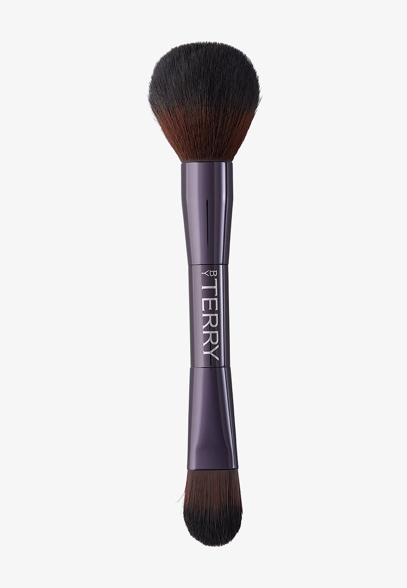 Dubbeländad makeupborste med lila handtag. Den ena sidan har ett tätt, rundat borsthuvud, medan den andra har en avsmalnande platt borste för precision.