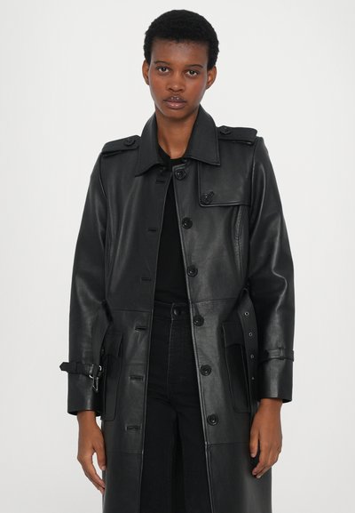 Black leather trench coat with a structured design, large collar, front buttons, and side pockets. Features adjustable sleeves with buckles.