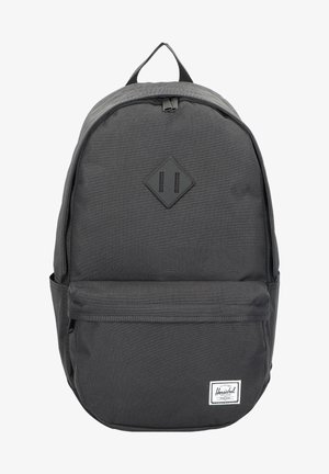 Zwarte stoffen rugzak met een gladde textuur, diamanten patch, ritsvak aan de voorkant en een wit merklabel aan de onderkant van de voorkant.