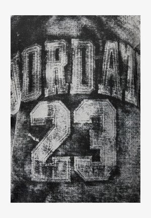 Schwarz-weißes Trikot mit dem Schriftzug "JORDAN 23" in fetter, abgenutzter Schrift. Das Design hat eine strukturierte Optik mit einem getragenen Effekt.