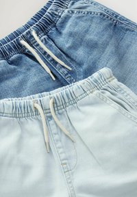 Twee paar denim shorts: één donkerblauw, één lichtblauw. Beide hebben een elastische tailleband met witte trekkoorden en een gladde textuur.