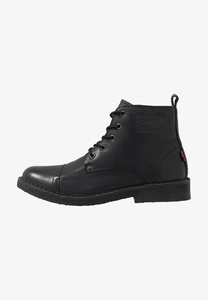 Botas de tobillo de cuero negro con un acabado texturizado, punta redonda, diseño de cordones, costuras en contraste y un pequeño logo en el lateral.