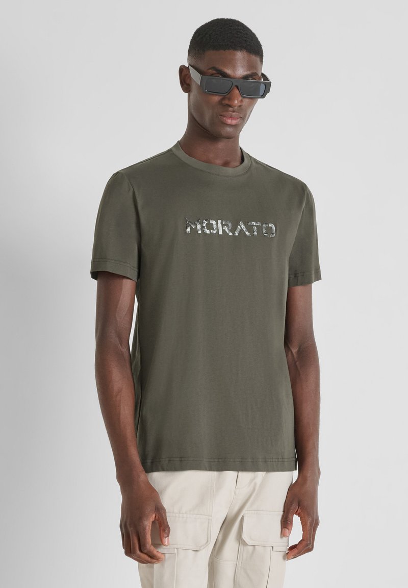 Camiseta de algodón verde oliva con mangas cortas y cuello redondo, que presenta el texto "Morato" en impresión reflectante en la parte frontal.