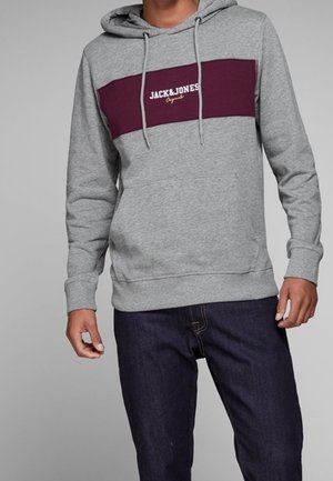 Sudadera gris con una franja horizontal en color burdeos que presenta el texto "JACK&JONES" en blanco; confeccionada en una mezcla de algodón con un bolsillo tipo canguro en la parte frontal.