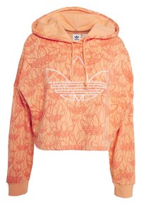 Cropped hoodie i ljusorange med ett repetitivt blommönster i mörkare orange. Har en huva med snörning och en vit logotyp i mitten.