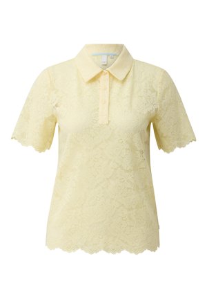 Jasnożółta koszulka polo z krótkim rękawem z koronką, z falistymi brzegami, trzema guzikami na listwie i klasycznym kołnierzem.