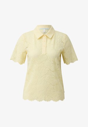 Jasnożółta koszulka polo z krótkim rękawem z koronką, z falistymi brzegami, trzema guzikami na listwie i klasycznym kołnierzem.
