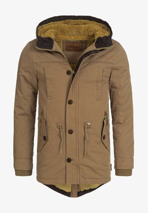 Tan winter coat featuring a shearling-lined hood, button closure, and multiple pockets with drawstring accents. Textured fabric and khaki lining.