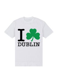 Bílý bavlněný tričko s velkým černým textem "I" a "DUBLIN," s grafickým motivem zeleného trojlístku mezi nimi.
