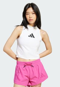 Vit kortärmad topp med hög halsringning och svart logotyp. Rosa träningstights med elastisk midja och sidomönster.