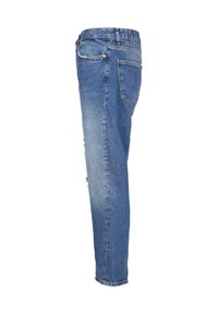 Jean en denim bleu vu de côté avec une poche arrière, des passants de ceinture et un léger effet usé au niveau de la cuisse.