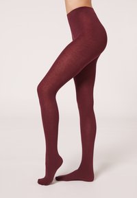 Collant bordeaux opaco con una texture liscia, caratterizzati da una vita alta e un design senza cuciture che si estende fino alle punte.
