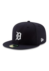 Gorra de béisbol azul marino con visera plana, que presenta un logotipo "D" bordado en blanco en relieve en la parte frontal y un logotipo pequeño en el lateral, fabricada en tela.
