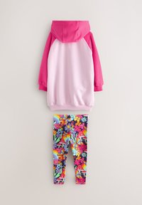 Felpa con cappuccio rosa e bianca, abbinata a leggings multicolore con motivi floreali e arcobaleno. Mix di cotone, design casual.