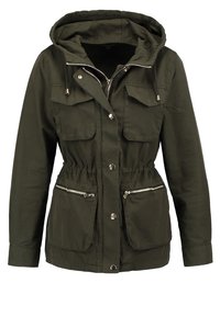 Oliwkowo-zielona kurtka na zamek z kapturem, ściągaczem w pasie, wieloma kieszeniami i srebrnymi detalami na zamku. Wykonana z gładkiego materiału.