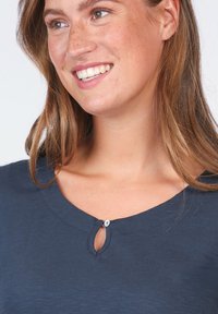 Navy blue top with a round neckline featuring a small keyhole detail and a button accent, made from a soft, textured fabric.