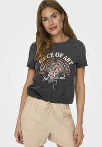 Grijs katoenen T-shirt met een grafisch ontwerp van rozen, tekst en stralen. Combinatie met beige textuuroveralls, geschikt voor casual draag.